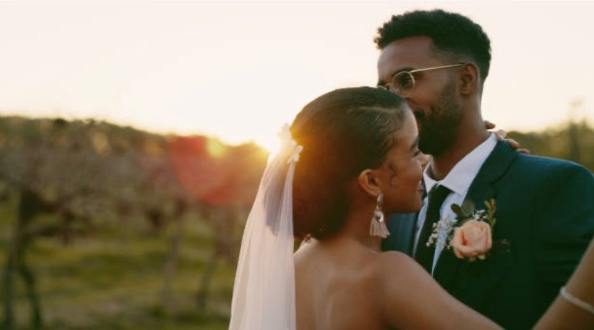 Couple at sunset in vineyard with warm golden hour lighting